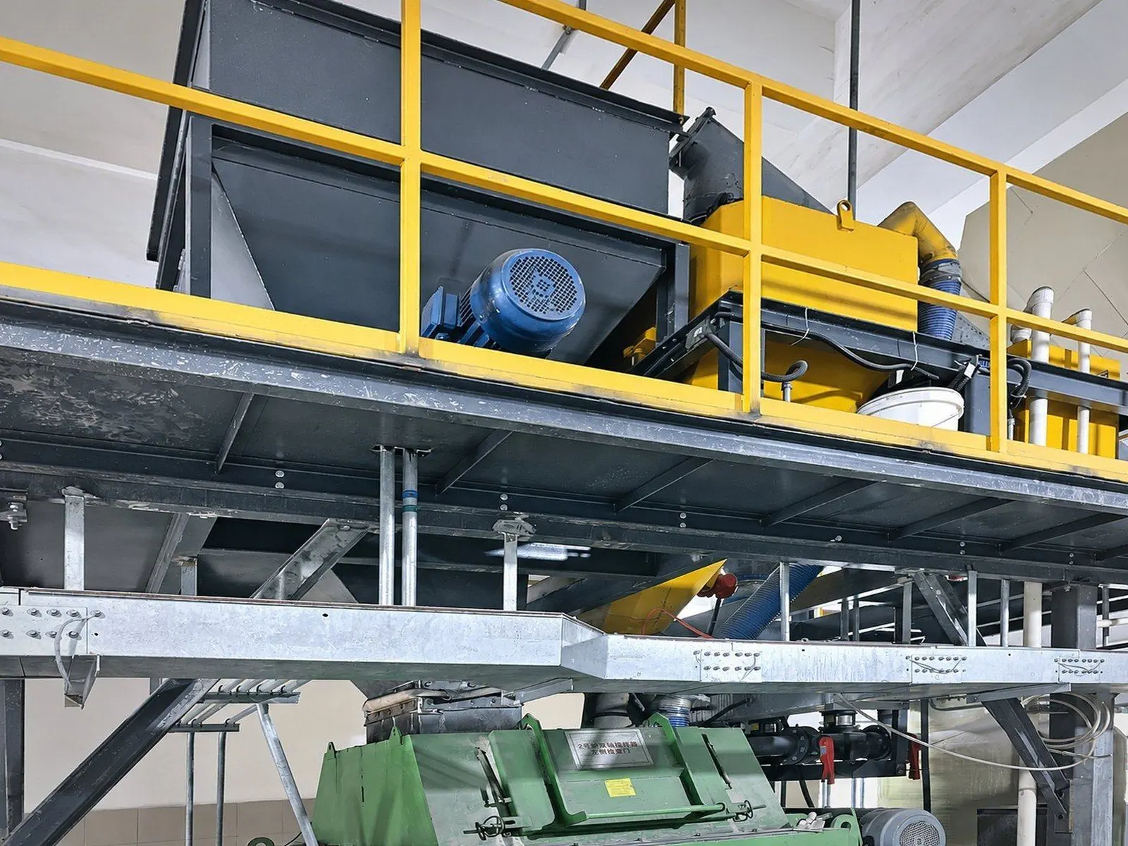 Dosing platform with hoppers and feeders above a green twin-shaft mixer