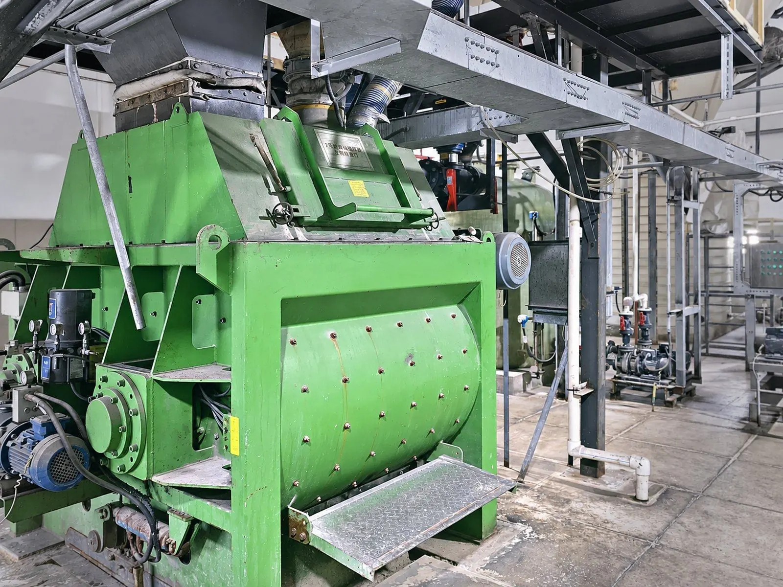 Green twin-shaft mixer installed under the dosing platform at a waste-to-energy plant in Shanxi