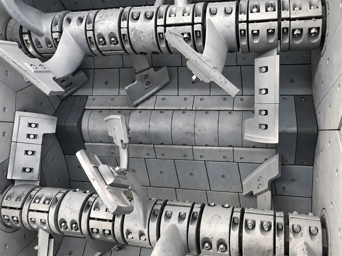 Inside a twin-shaft mixer: shafts with bolted wear-resistant paddles and liner plates