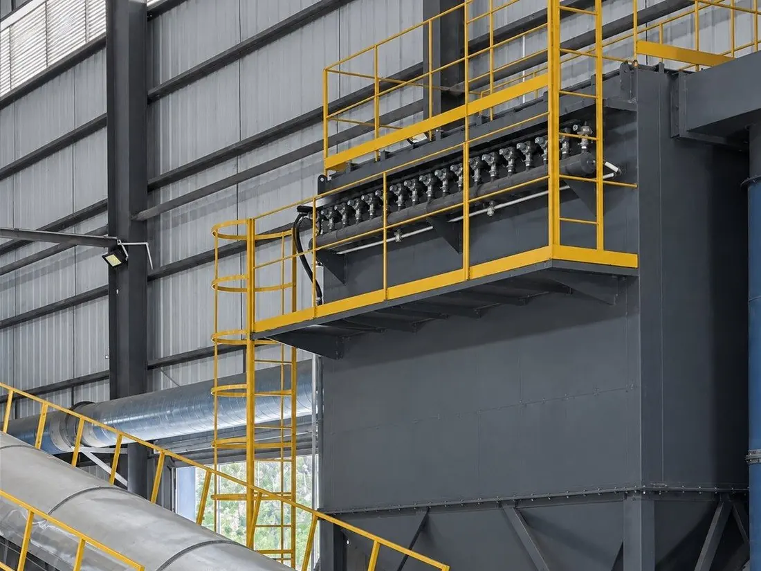 Large pulse-jet bag filter with a row of pulse valves under its yellow service platform
