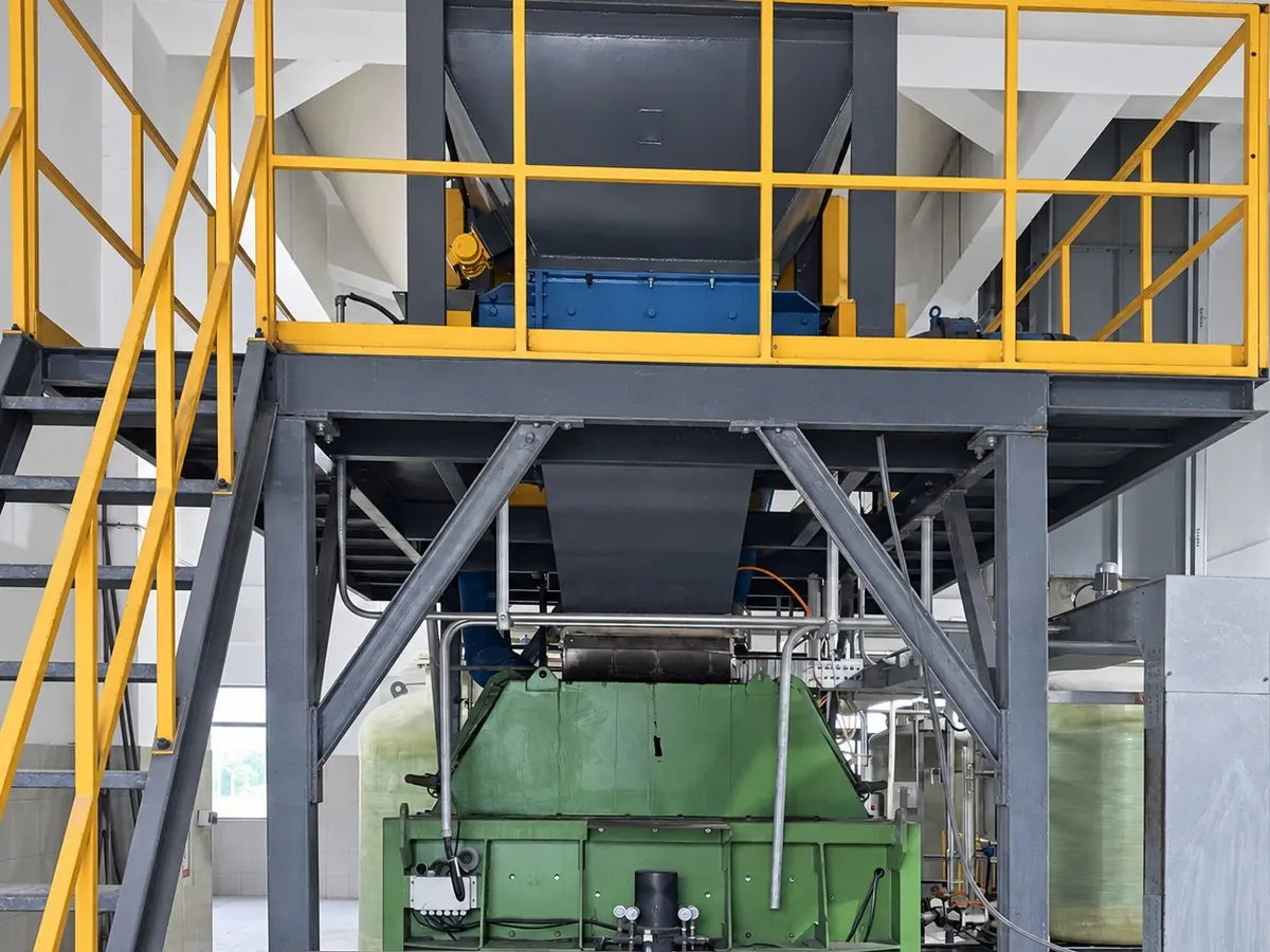 Platform with hopper and drive above the green twin-shaft mixer on a fly ash line at a waste-to-energy plant in Shanxi